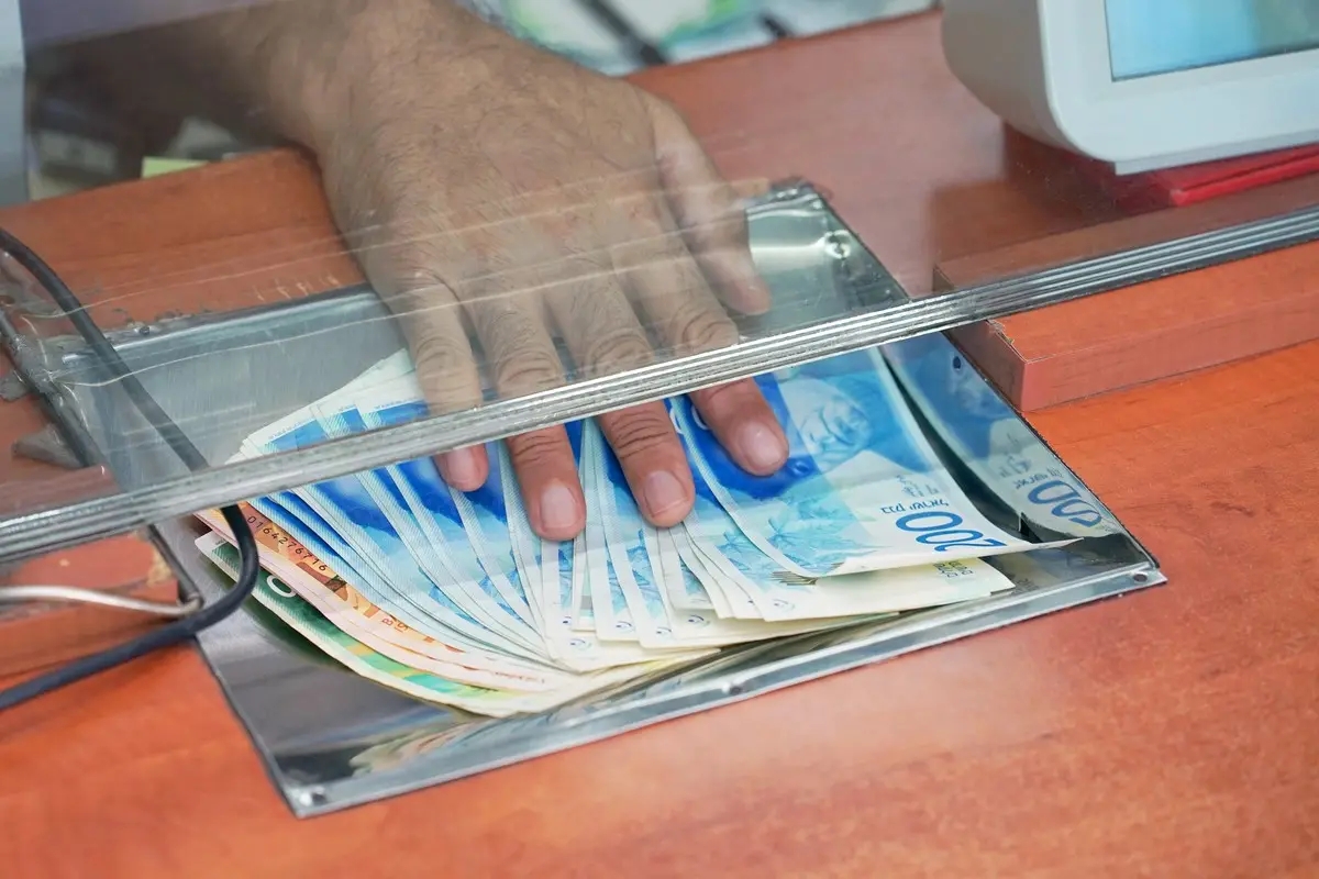 kasjer przekazujący banknoty w kantorze